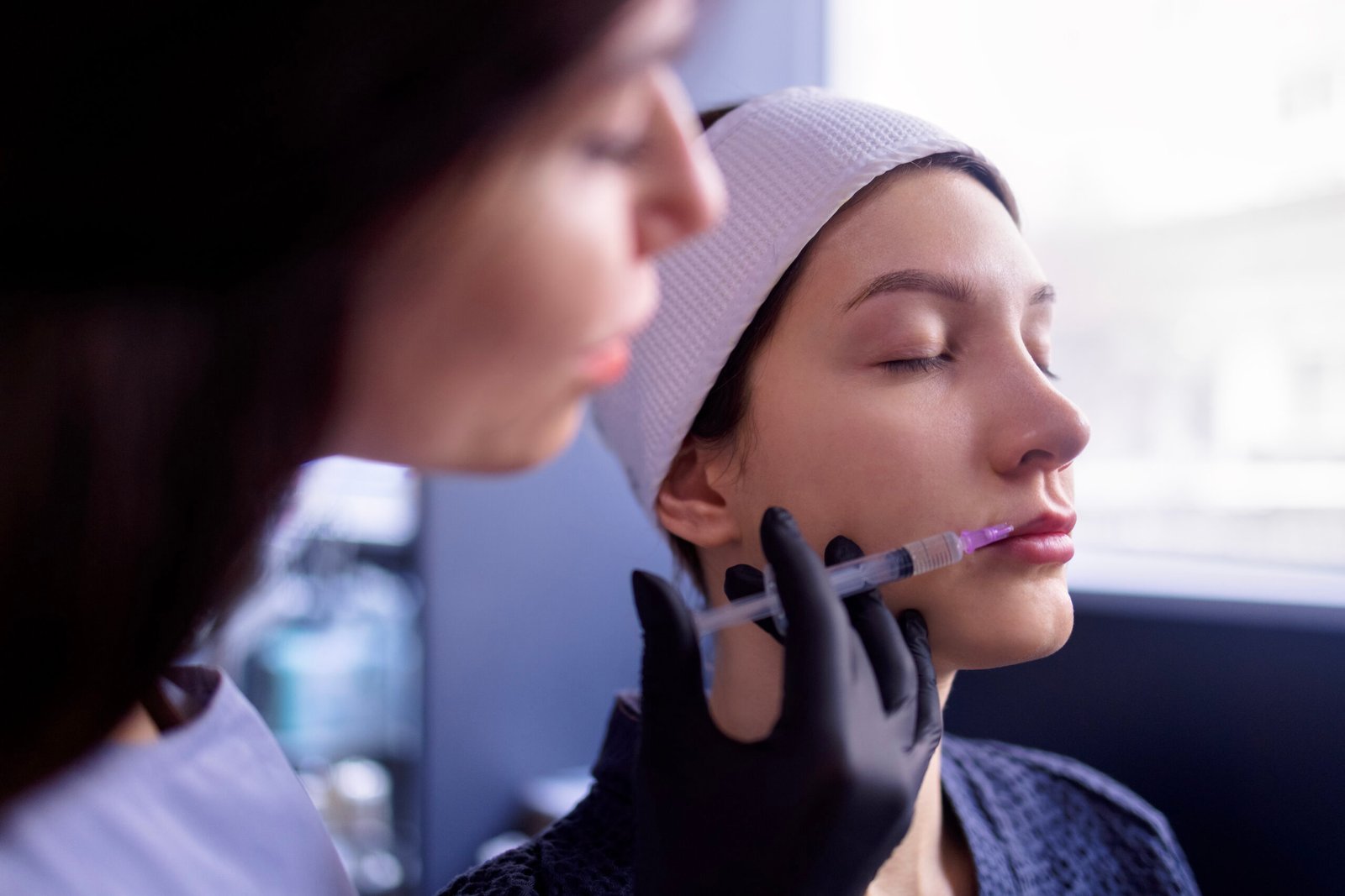 Female cosmetologist performing beauty lip filler injection at Couture Dermatology and Laser Beverly Hills