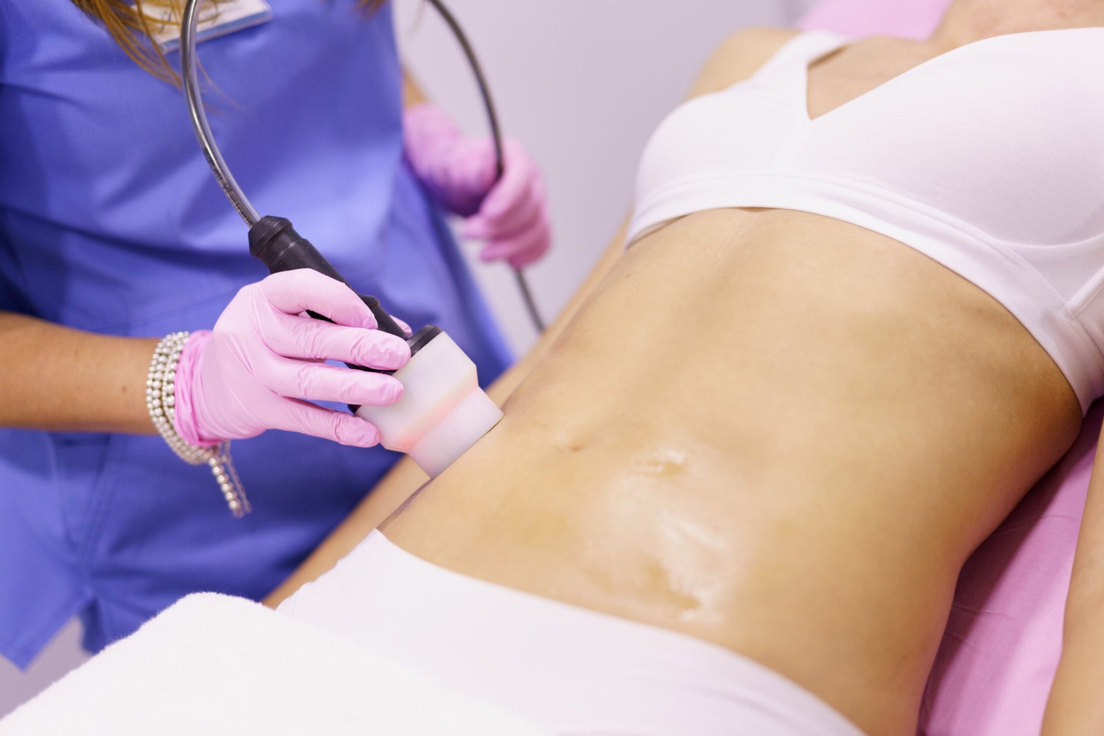 Woman receiving radiofrequency body contouring treatment at Couture Dermatology and Laser
